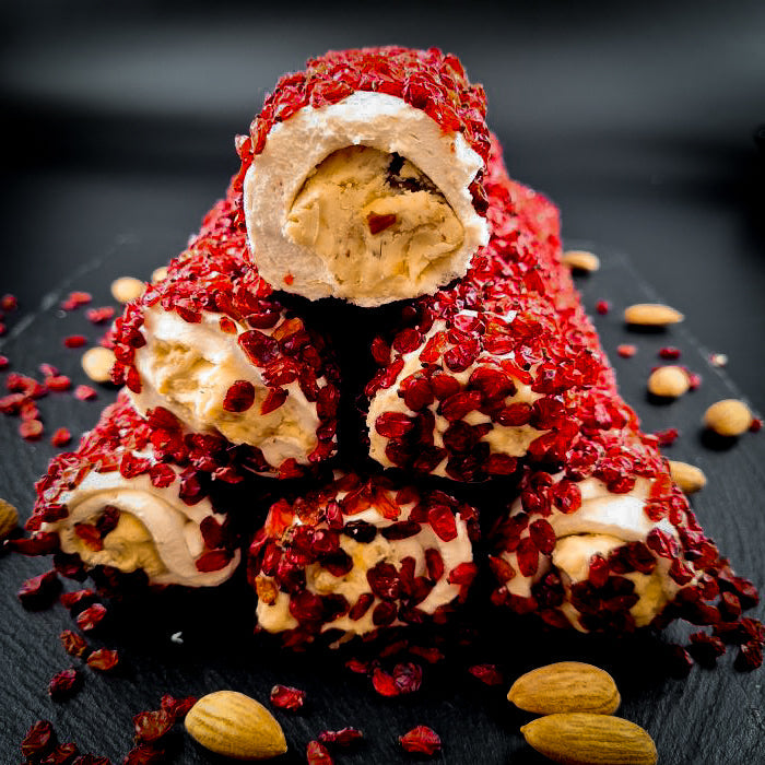 Piena-vaniļas lukums ar maigu mandeļu krēmu, pārkaisīts ar granātābola sēklām